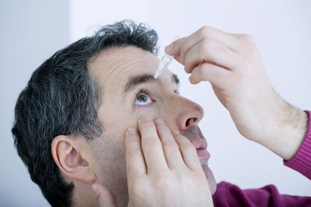 Man putting in best eye drops