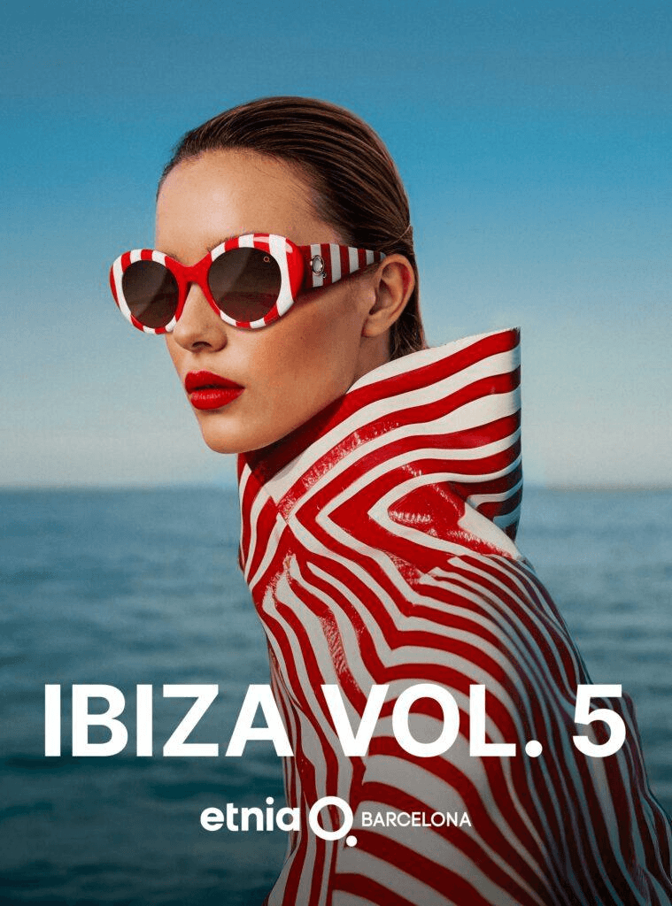 A fashion model wearing bold red and white striped sunglasses and a matching high-collared coat from the Etnia Barcelona Ibiza Vol. 5 collection.